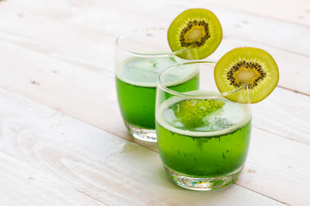 Kiwi smoothie in glass on a old white wooden の写真素材