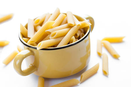Italian pasta. Dry pasta on white wooden boardの写真素材