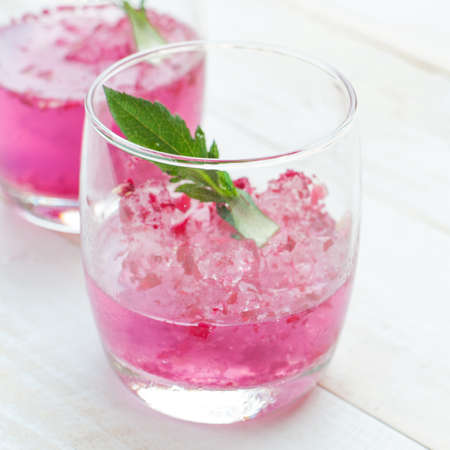 Pink Cocktail with fresh rose petals on wooden tableの写真素材