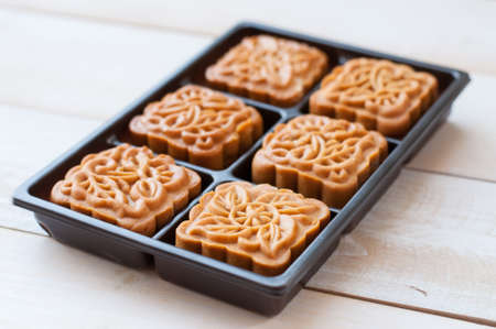 Retro vintage style Chinese mid autumn festival foods. Traditional mooncakes on table setting with teacup.の写真素材