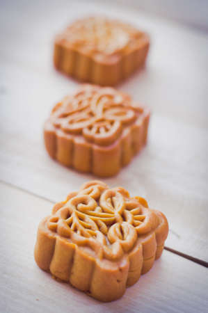 Retro vintage style Chinese mid autumn festival foods. Traditional mooncakes on table setting with teacup.の写真素材
