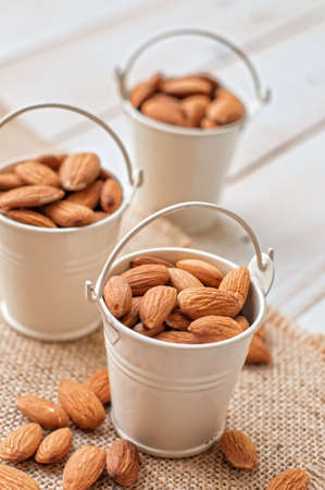 Raw almonds on white wooden boardの写真素材