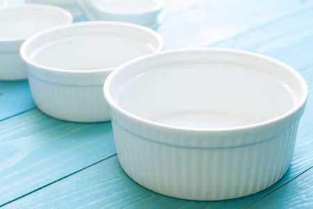 White Ramekin bowl on blue wooden boardの写真素材