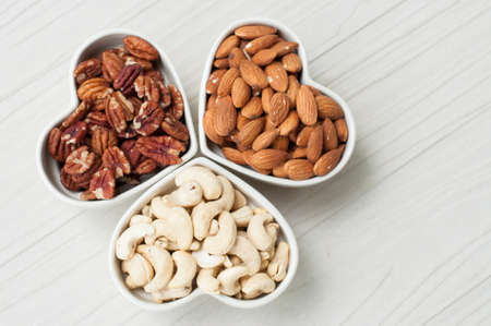 Assorted nuts in bowl on wooden tableの写真素材