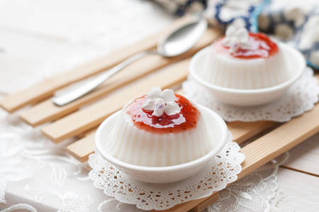Panna cotta with raspberry sauce on white lace background, italian dessertの写真素材