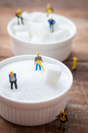 Miniature toy worker work with sugarの写真素材