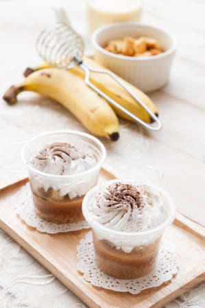 banoffee pie in a cup, spilled with caramel and whipped cream, delicious dessert.の写真素材