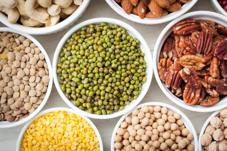 collection set of beans, legumes, peas, lentils in ceramic bowl on white wooden backgroundの写真素材