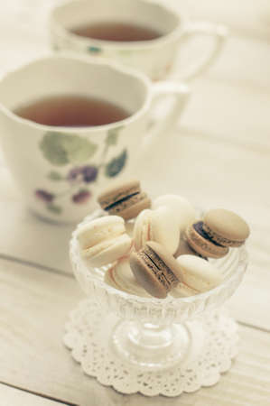 macaroons with cup of tea on color wooden tableの写真素材