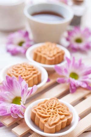 Mid-Autumn Festival moon cake on wooden board with Chrysanthemum petals, Chinese dessertの写真素材