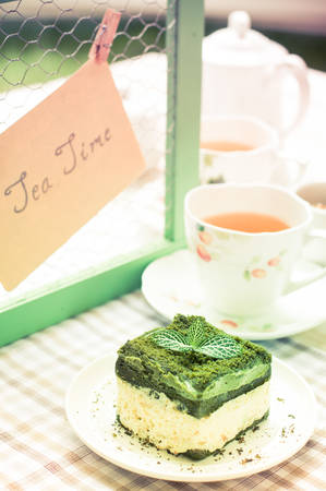 green tea cake and a cup of tea, tea set on white wooden board, Afternoon tea timeの写真素材