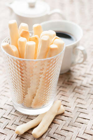 Breadsticks in glass on wooden background.
