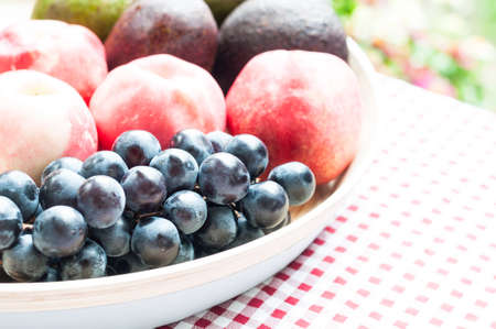 Grapes, peach and avocado on tableの写真素材