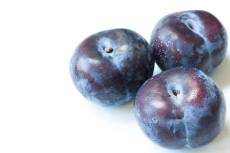 Three ripe plums isolated on white background