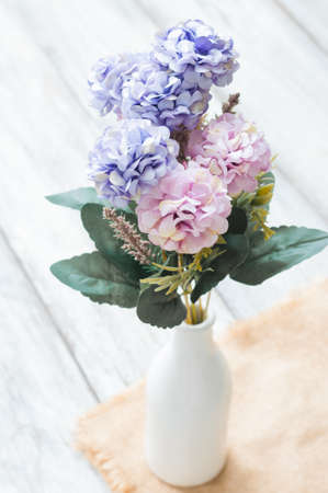 Beautiful artificial flowers on wooden backgroundの写真素材