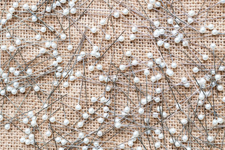 Sewing pins on burlap backgroundの写真素材