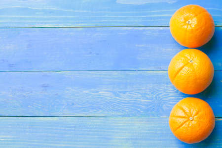 Ripe mandarin orange on blue backgroundの写真素材