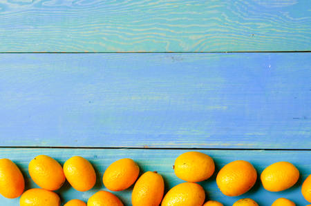 Orange kumquat fruit on blue wooden backghroundの写真素材