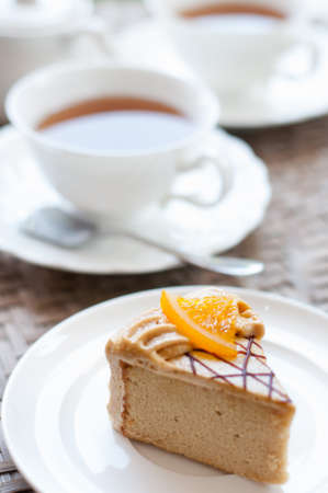 Afternoon tea set and coffee cake on white wooden board in soft toneの写真素材
