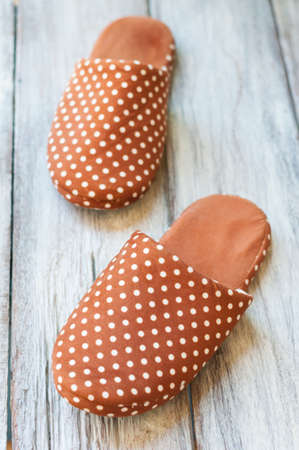 Brown with white polka dot Slippers on wooden floorの写真素材