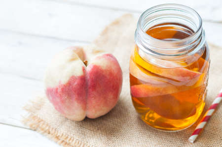 Peach tea putting on burlap and wooden boardの写真素材