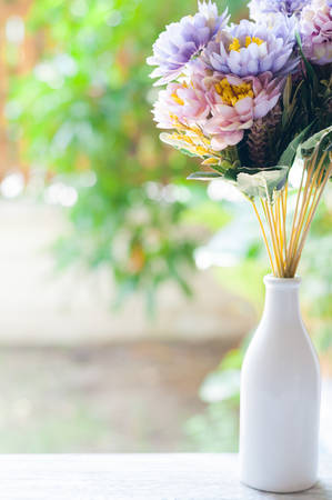 Beautiful artificial flowers on orange curtain backgroundの写真素材