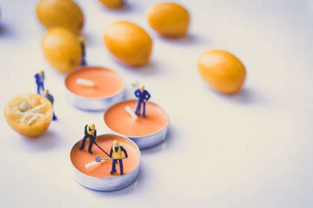 Orange aroma candles with miniatures on grey backgroundの写真素材