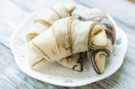 coffee and green tea croissant bread on wooden backgroundの写真素材