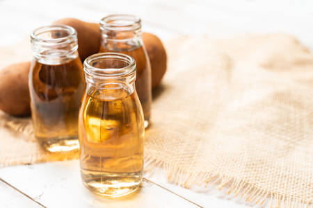 Yacon syrup in bottles with yacon rootsの写真素材