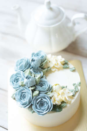 Blue Buttercream flower cake on wooden backgroundの写真素材