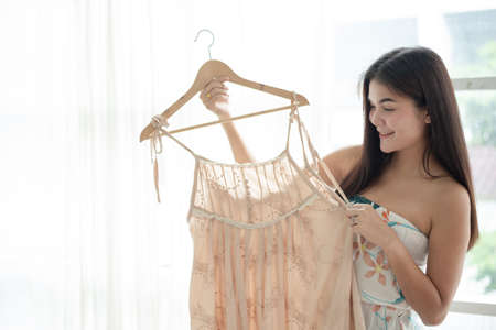 Woman choosing dress at cloth shopの写真素材