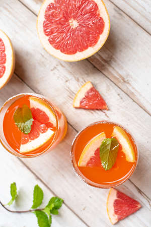 Glasses of grape fruit juice on wooden backgroundの写真素材