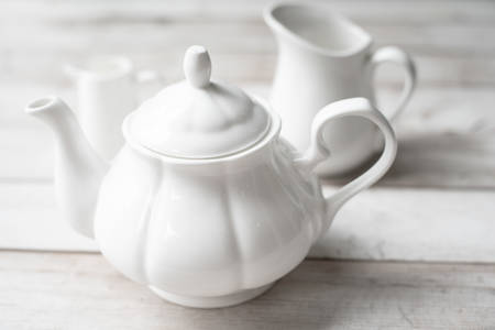 White ceramic teapot ang jug on wooden backgroundの写真素材
