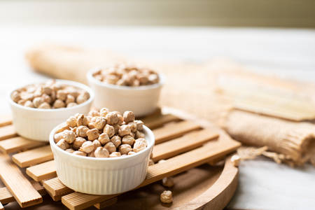 Chick pea in ramekin on wooden backgroundの写真素材