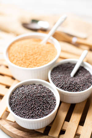 Back and yellow Mustard seed on wooden backgroundの写真素材