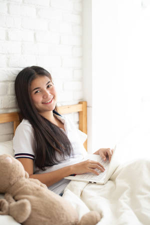 Woman using laptop to shopping online in bedroomの写真素材