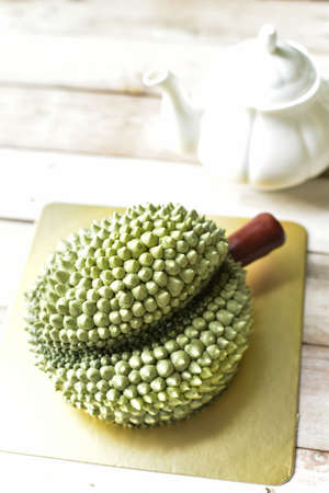 Durian cake made from buttercream, on wooden backgroundの写真素材