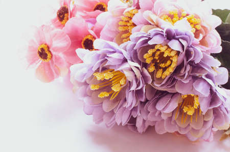 Purple and pink artificial flowers on grey backgroundの写真素材