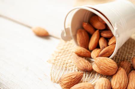 Almonds in white steel bucketの写真素材