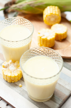 Fresh yellow sweet corn on the cob and corn juiceの写真素材