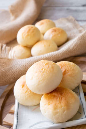 Bun with icing topping on wooden backgroundの写真素材