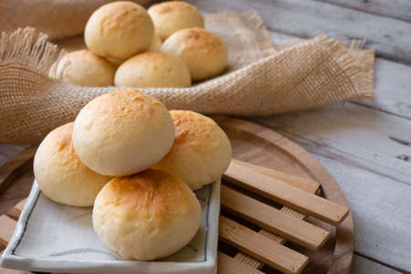 Bun with icing topping on wooden backgroundの写真素材