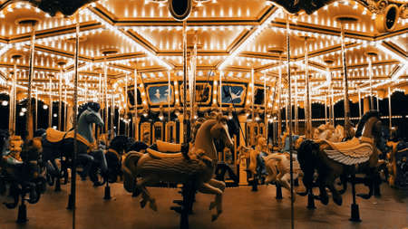 Merry-go-round carousel in amusement park at nightの写真素材
