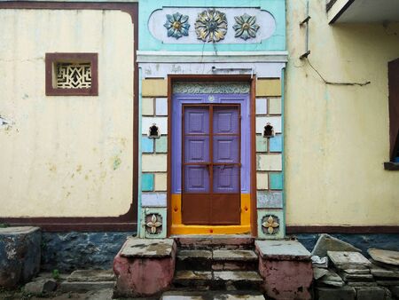 A beautiful house entrance door of an Indian village, Solapur, India. An entrance is made out of strong stones with fresh vibrant colours and rangoli in front of a home.の写真素材