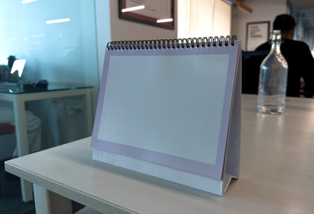 Blank empty calendar on a wooden office desk table. clean desk calendar display mockup for Presentation.の写真素材