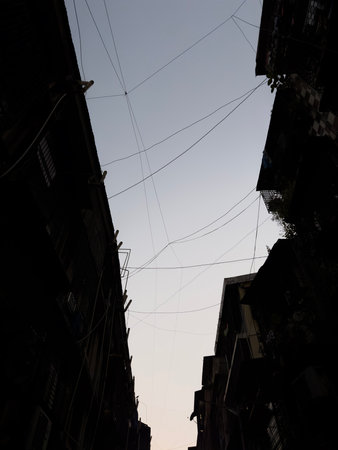 Upside evening clean sky view from the two old buildings and wires connecting to each others....