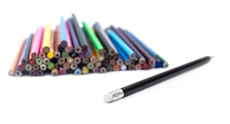 black pencil with an eraser on the background of a pile of colored pencilsの写真素材