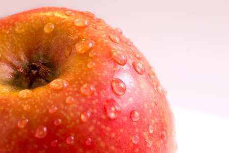 Wet red apple with drops close up, macroの写真素材