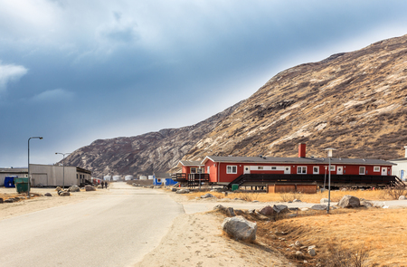 Street in Kangerlussuaq settlement with small living houses among mountains, Greenlandの写真素材
