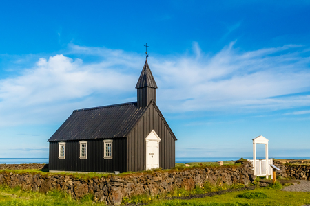 Budakirkja black painted lutheran parish erected in 1847 with blue sky and clouds in the background, Snaefellsnes Peninsula, West Icelandの写真素材